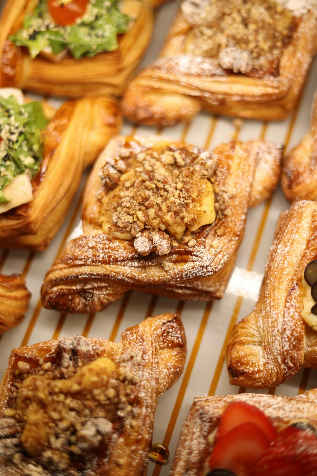 Close-up of assorted pastries topped with nuts and fruits, perfect for a gourmet snack.